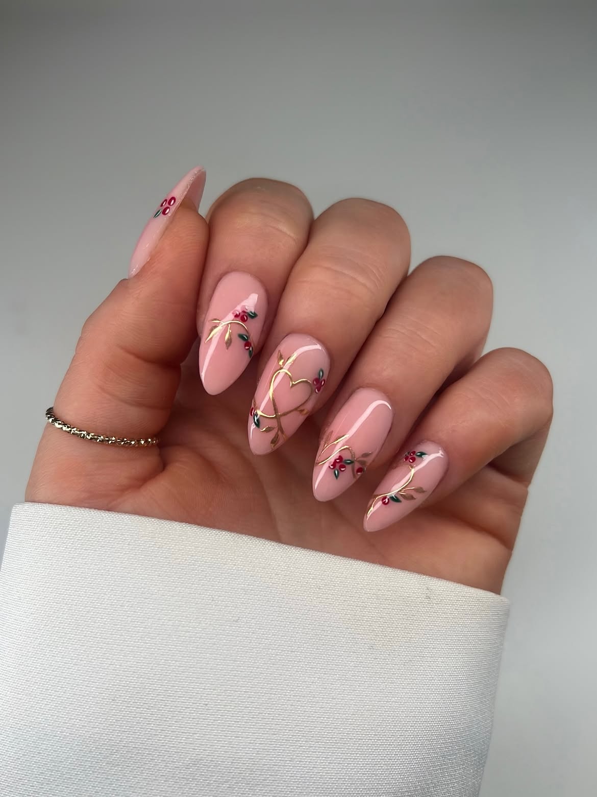 Glossy Nude Pink Almond Nails with Gold Vines and Red Berries