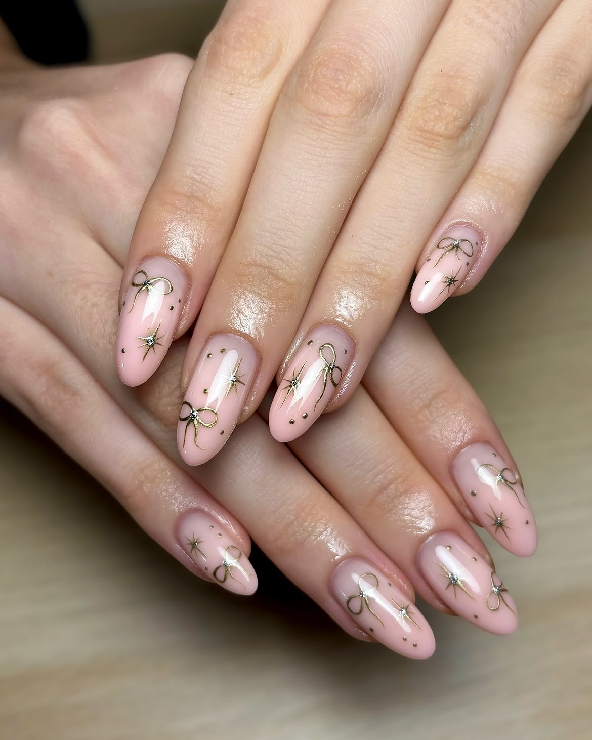 Glossy Pink Almond Nails With Gold Bows