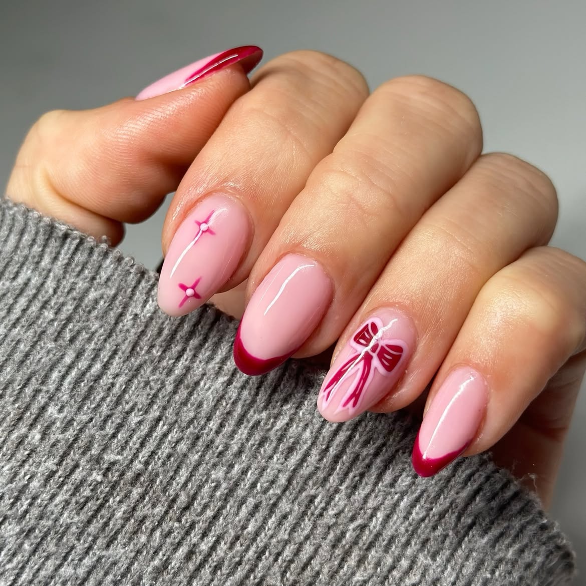 Glossy Pink French Tips With Red Bow Nail Art