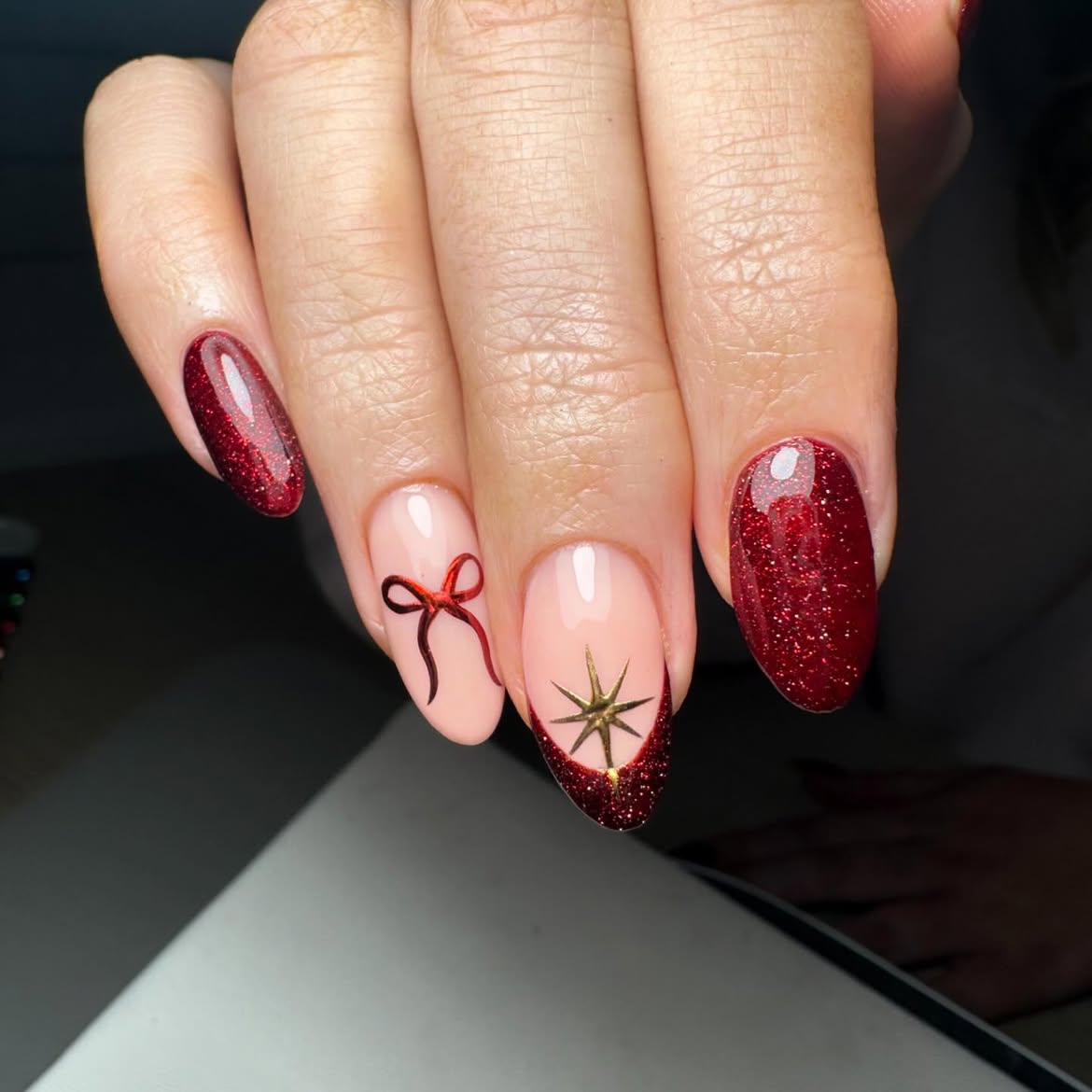 Glossy Red Glitter Nails with Christmas Bow Art