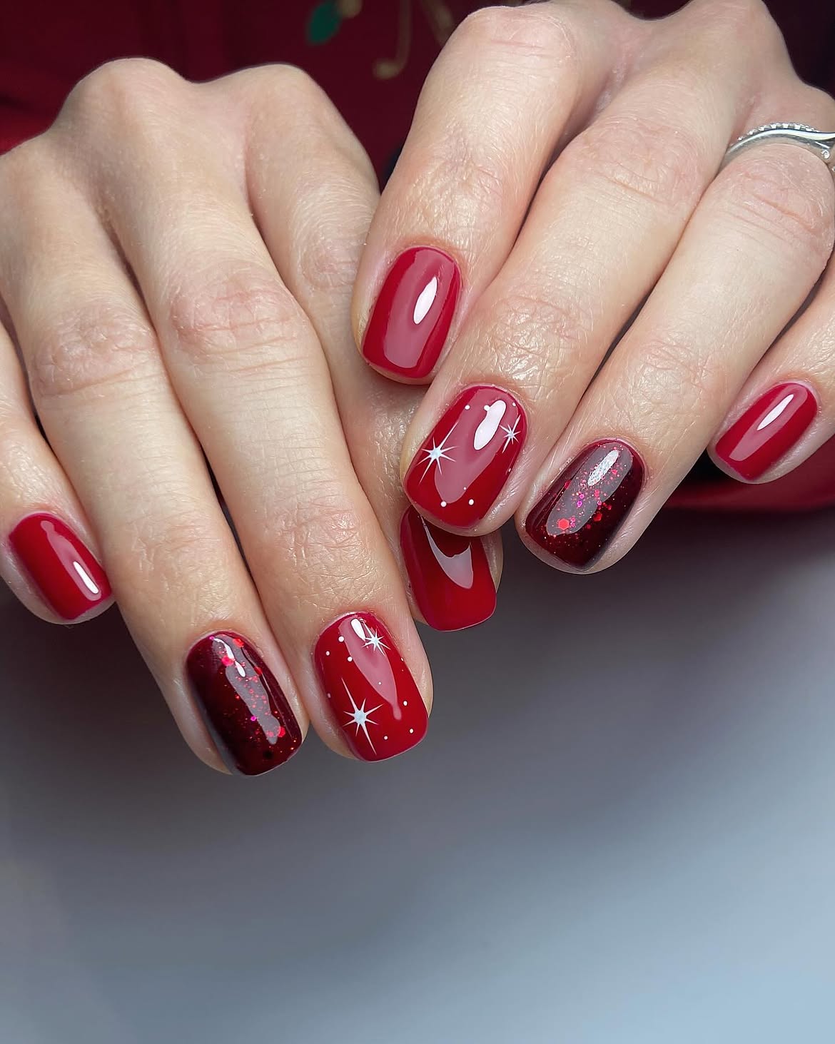 Glossy Red Holiday Nails With White Stars And Glitter