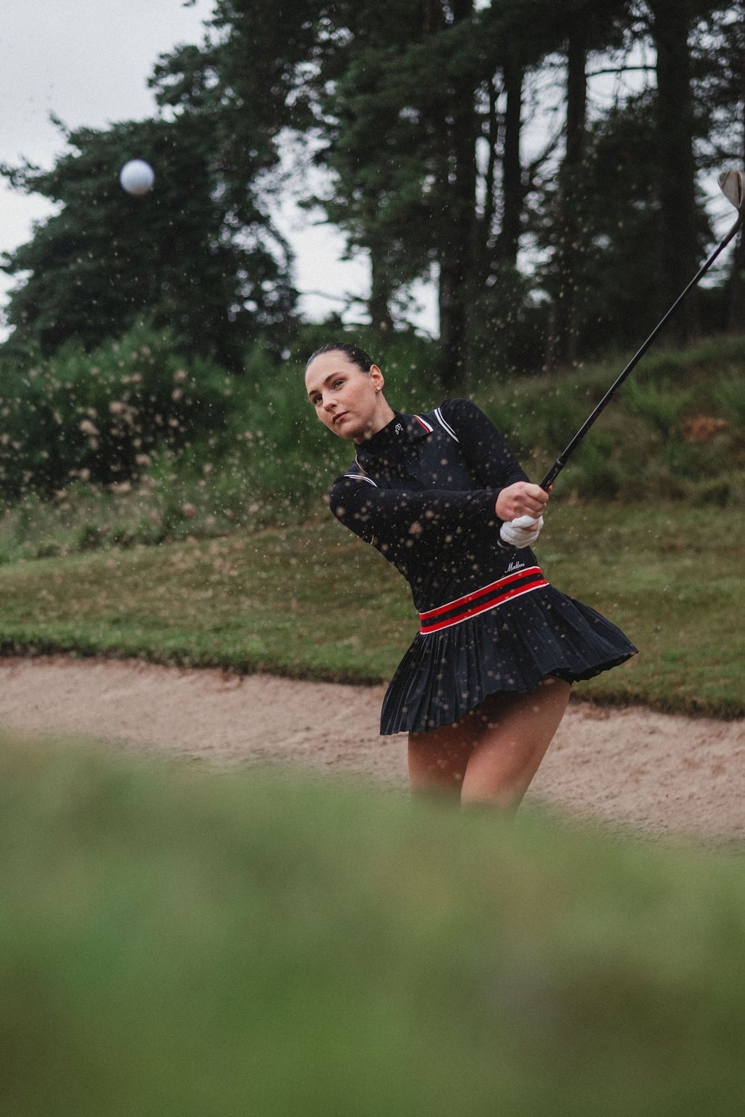 Black long-sleeve top and pleated skirt with red trim Black long-sleeve top and pleated skirt with red trim — Golf Outfits