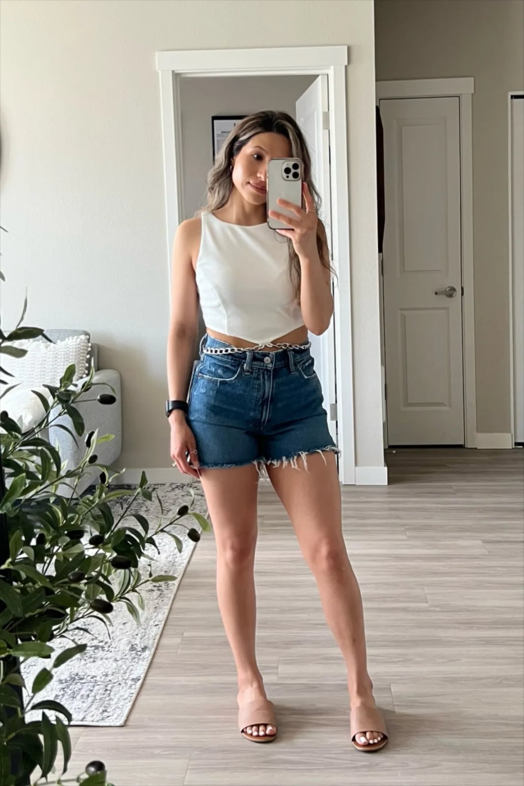 Distressed denim shorts with a white cropped top and chain belt Distressed denim shorts with a white cropped top and chain belt — Jean Shorts Outfits