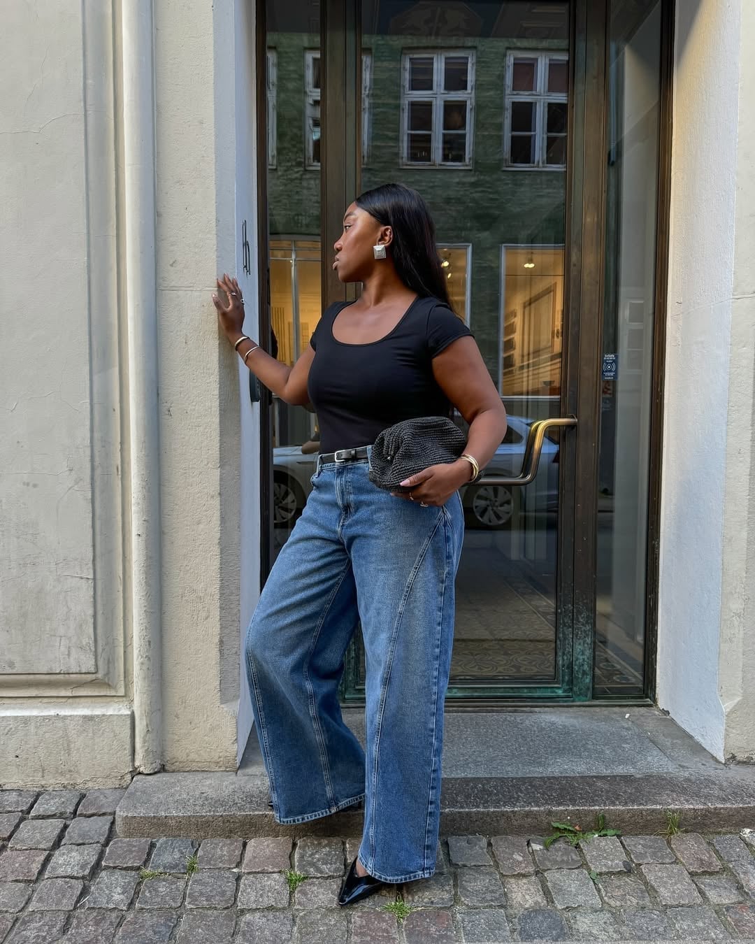 Medium blue wide leg jeans with black top and clutch Medium blue wide leg jeans with black top and clutch — Jeans Outfits