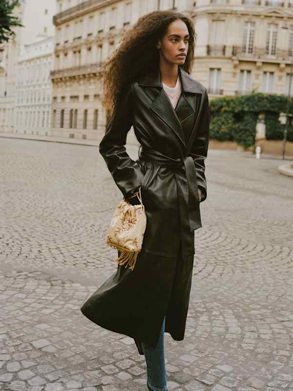 Long black leather trench coat over white top and blue jeans Long black leather trench coat over white top and blue jeans — Leather Jacket Outfits Women