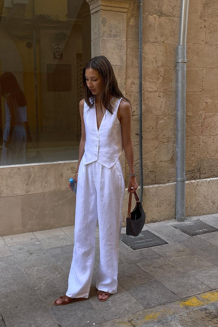 White straight-leg linen pants with a matching vest and brown handbag White straight-leg linen pants with a matching vest and brown handbag — Linen Pants Outfits