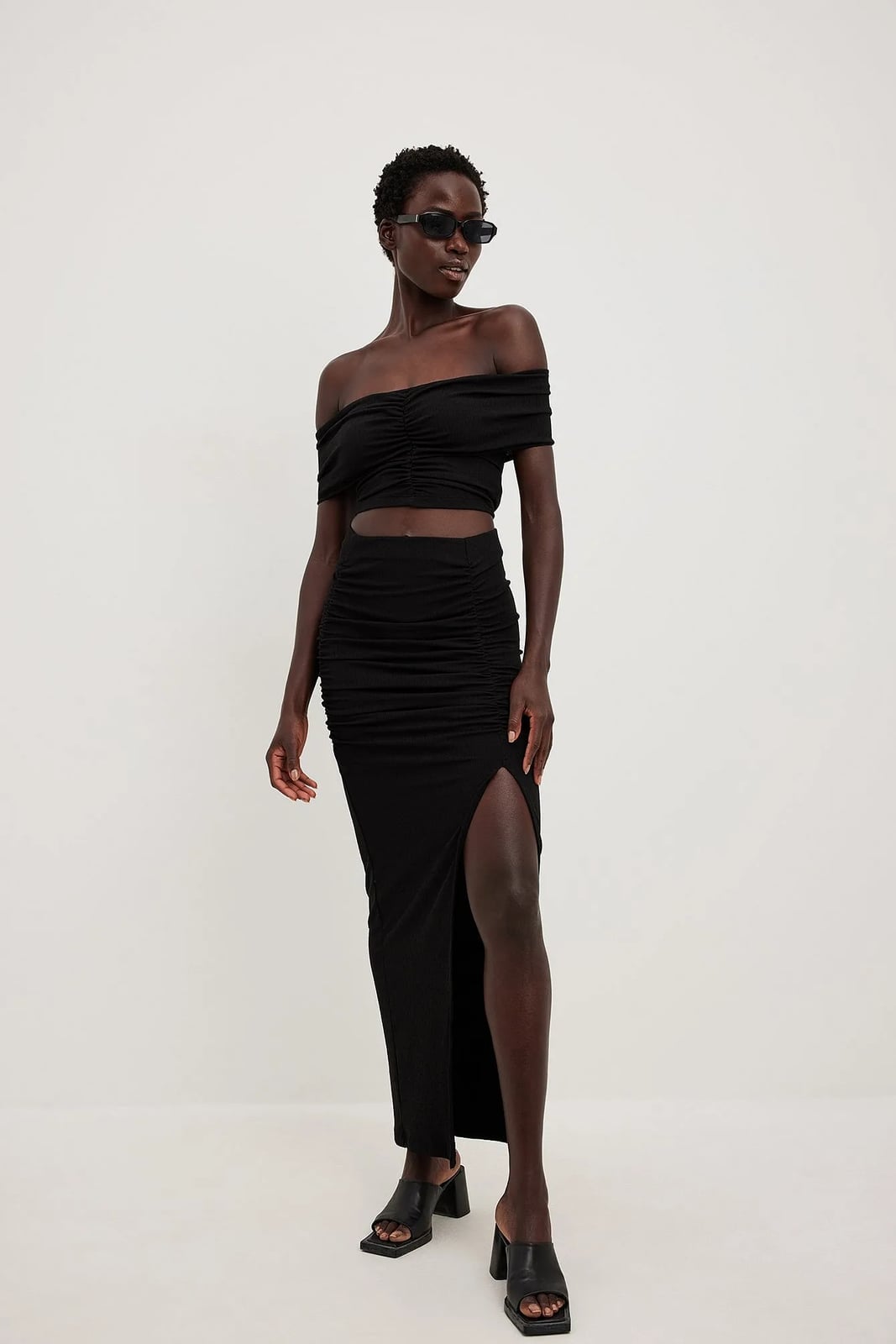 A Black Ruched Maxi Skirt With A Matching Crop Top A Black Ruched Maxi Skirt With A Matching Crop Top — Maxi Skirt Outfits