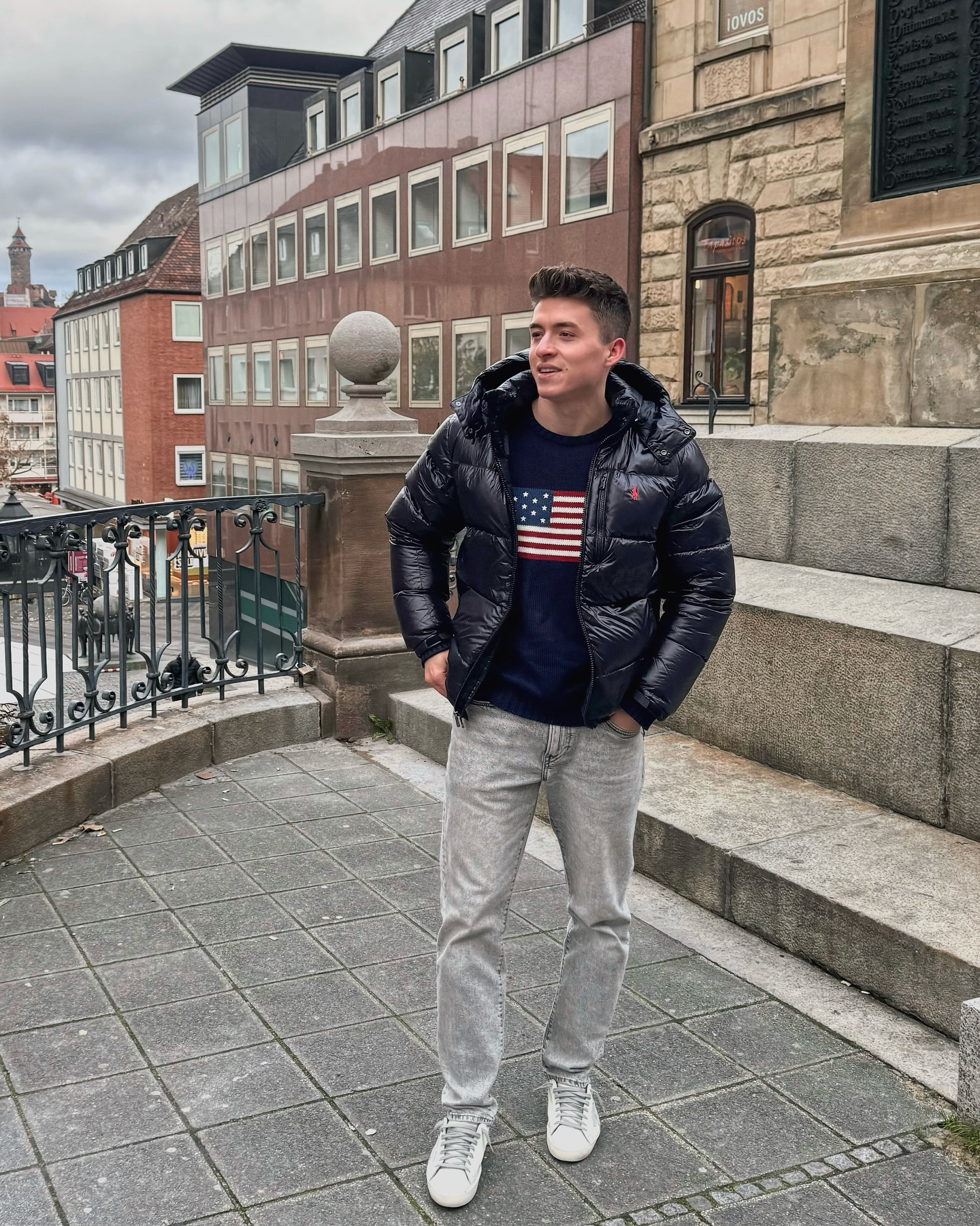 Navy Puffer Jacket With Flag Sweater And Grey Jeans