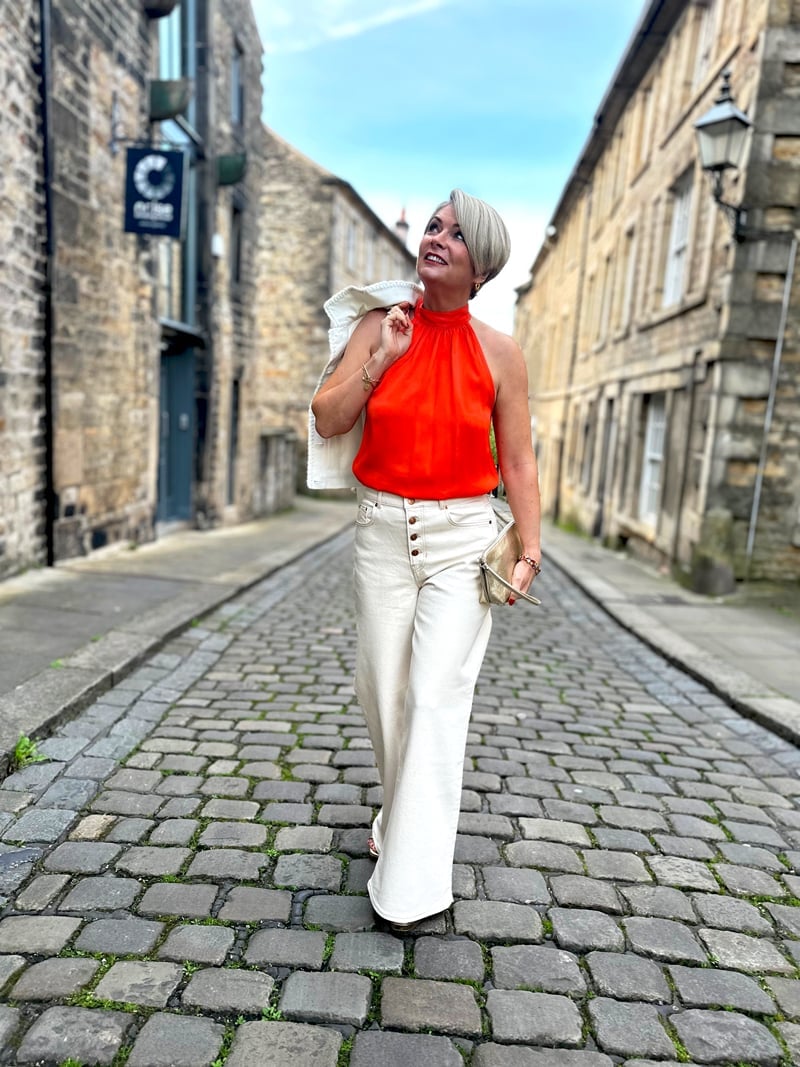 Cream wide-leg trousers with vibrant orange halter top Cream wide-leg trousers with vibrant orange halter top — Outfits for Women Over 50