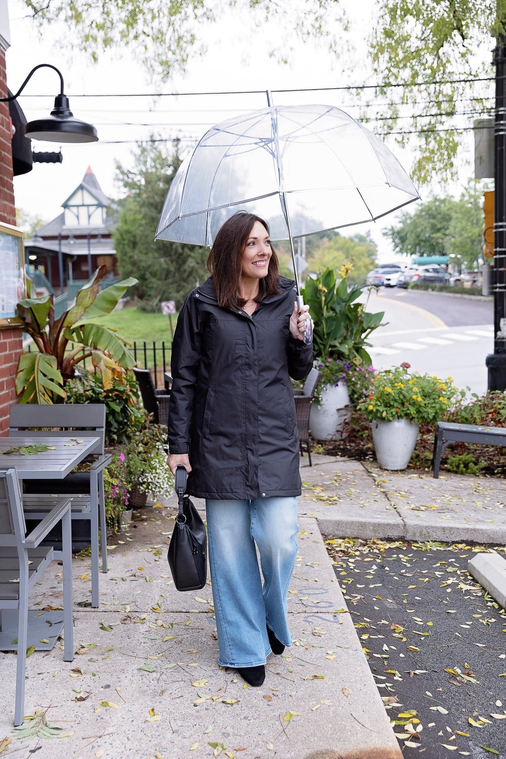 Black waterproof jacket over black top and light blue jeans Black waterproof jacket over black top and light blue jeans — Rainy Day Outfits