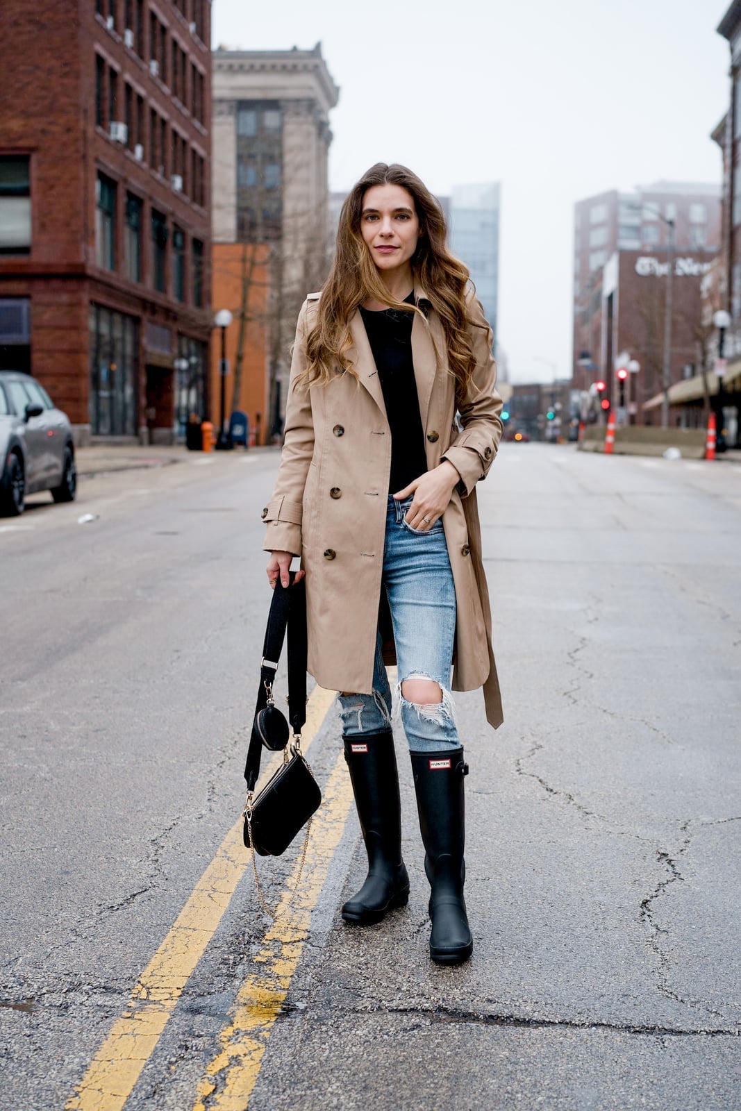 Beige trench coat over black top and ripped light wash jeans Beige trench coat over black top and ripped light wash jeans — Rainy Day Outfits