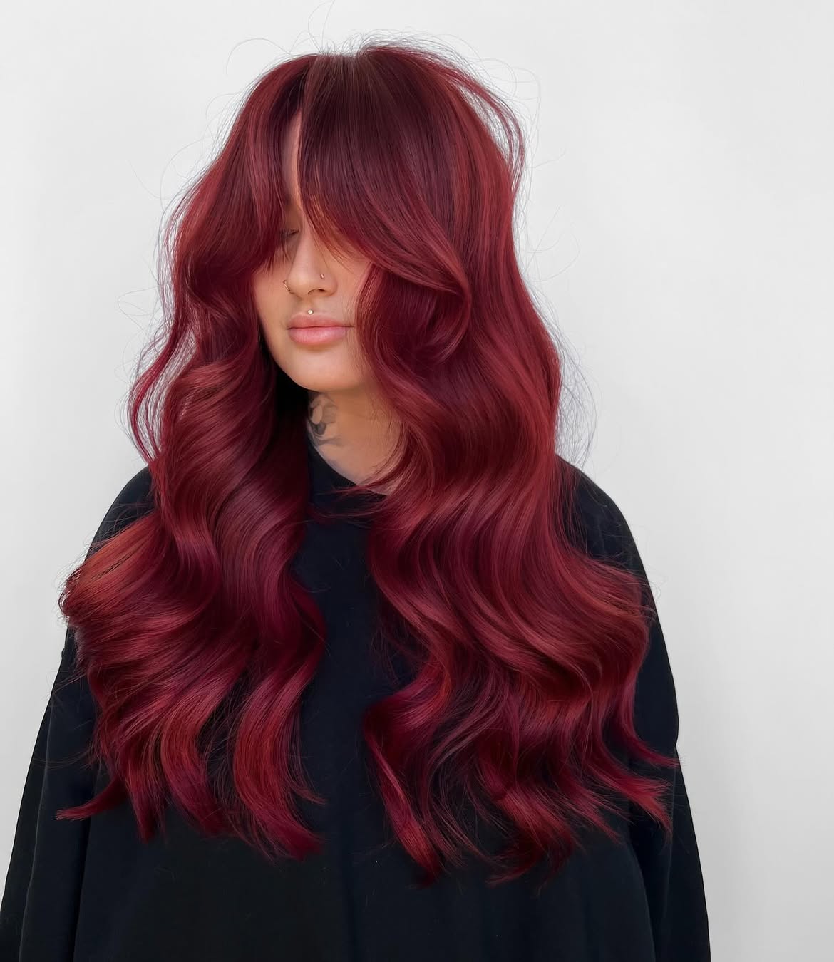 Rich Burgundy Red Hair With Curtain Bangs And Soft Waves