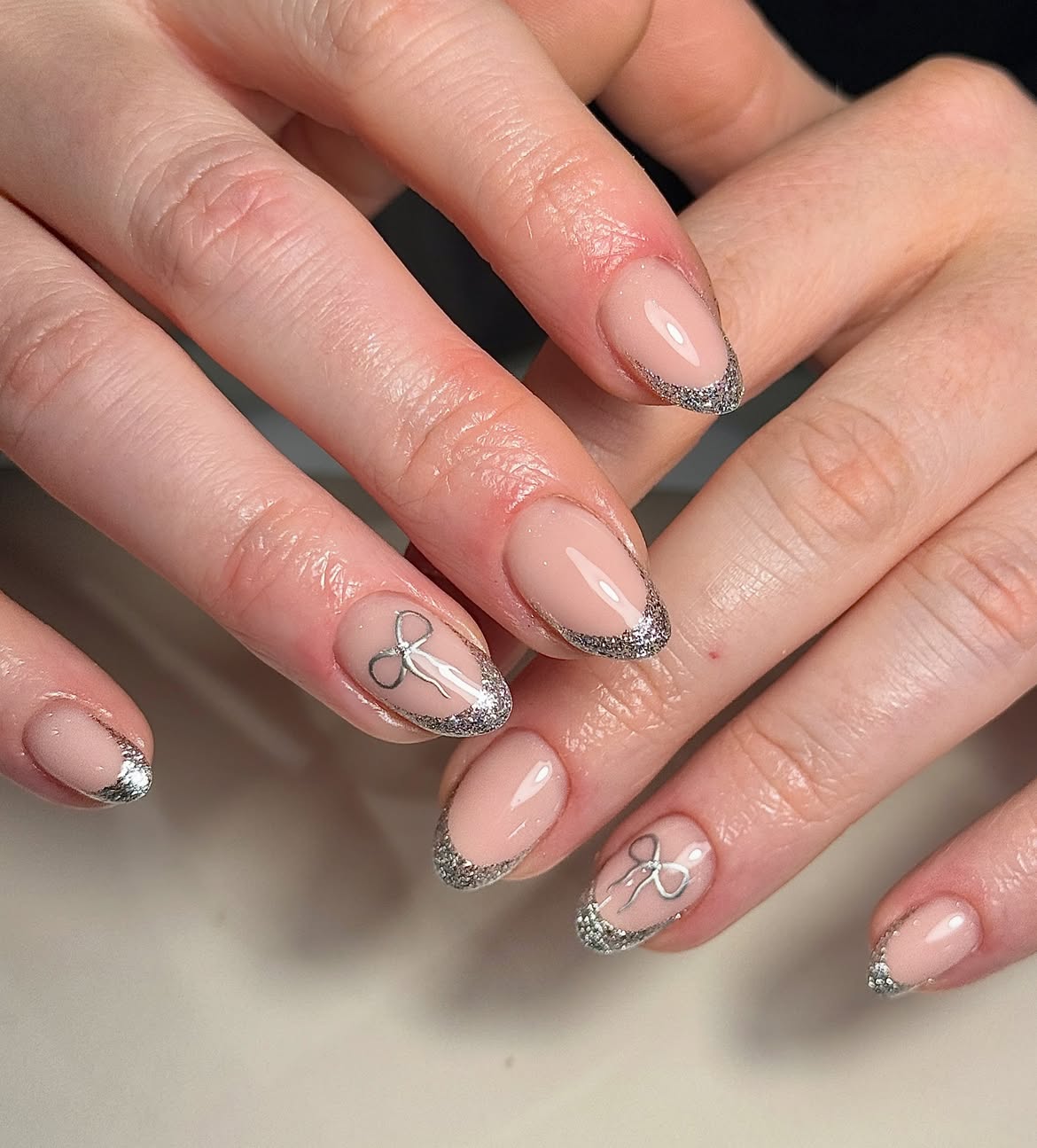 Sparkling Silver Bow French Tip Almond Nails
